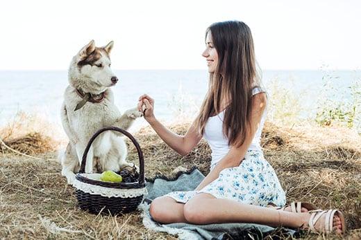 Mujer sosteniendo un  husky siberiano rojo